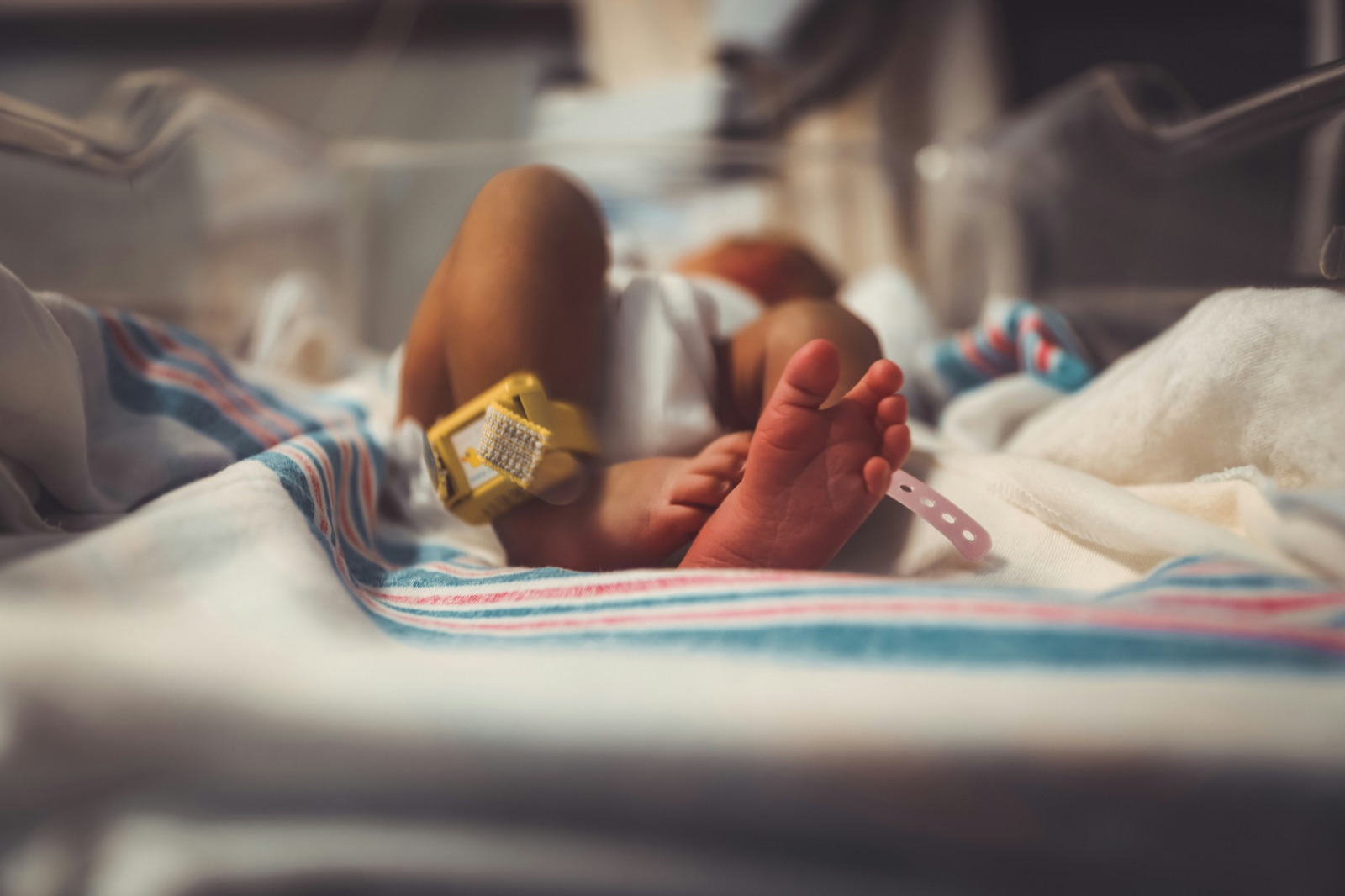 Newborn baby’s feet resting on a hospital blanket